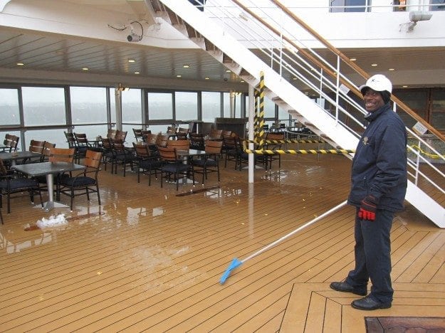 Shoveling snow on the deck on an end of the season Canada New England cruise