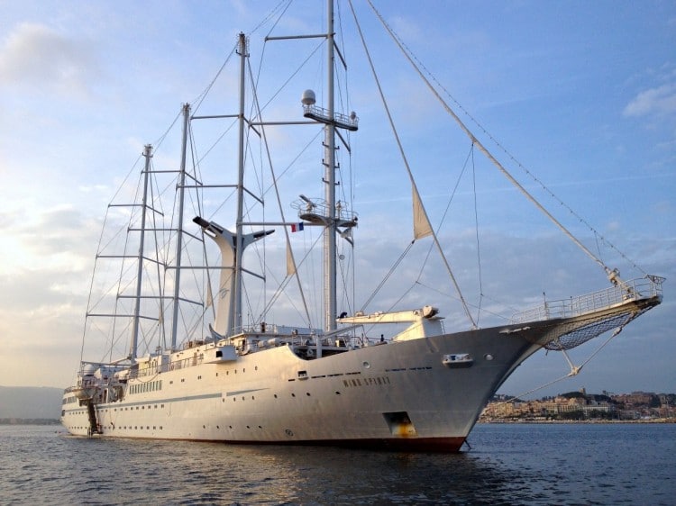 At sunset, the Windstar Wind Spirit is about to raise the anchor to depart the port of Cannes. 