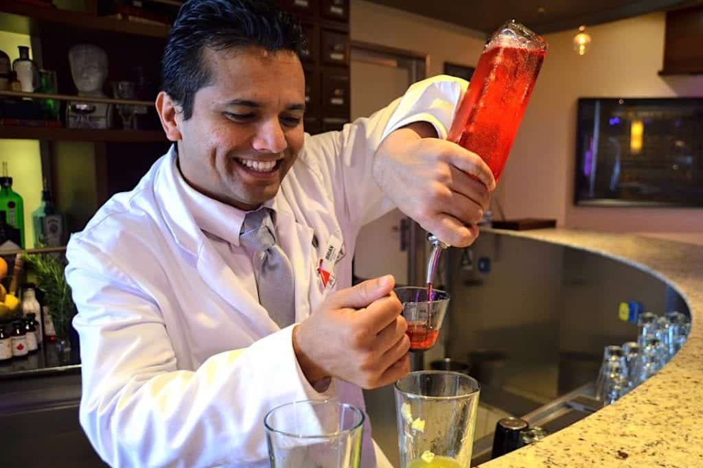 Bartender pours a cocktail at the Alchemy Bar 