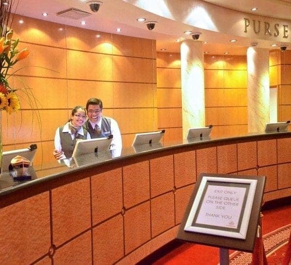 Saying hi to the front desk staff, here it's Cunard Queen Mary 2, is one of my 12 cruise hacks for women cruising solo