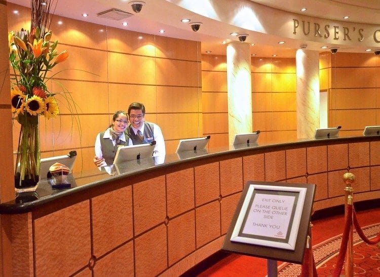 Saying hi to the front desk staff, here it's Cunard Queen Mary 2, is one of my 12 cruise hacks for women cruising solo