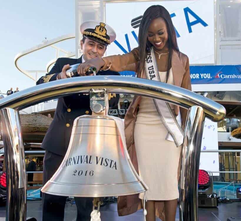 Carnival Vista captain Luigi De Angelis and Miss USA Deshauna Barber, right, pour champagne over a ship's bell(Andy Newman/Carnival Cruise Line/HO)