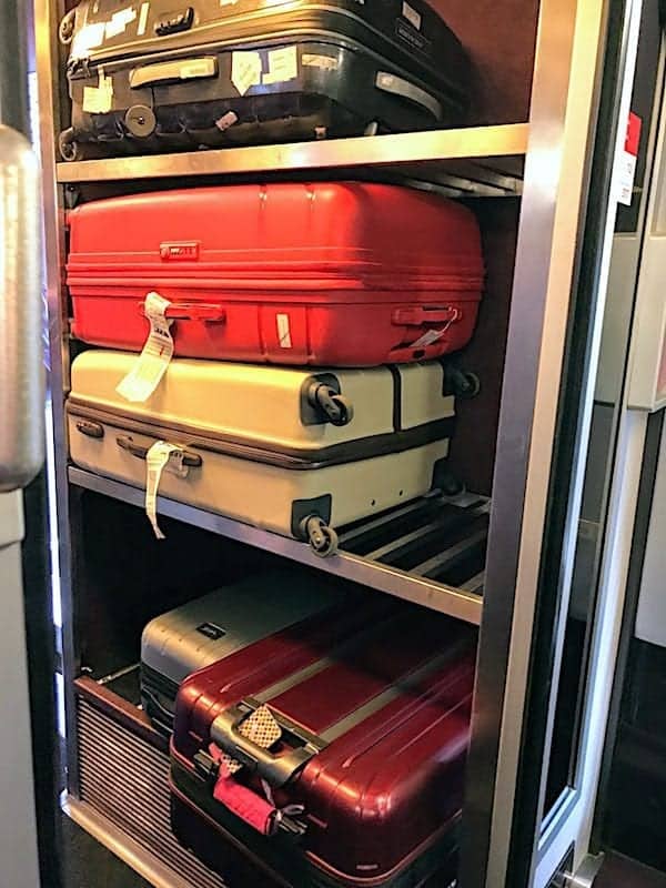 stack of suitcases on rack on train