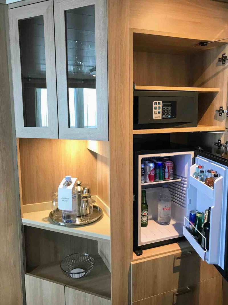 The corner of the stateroom has a minibar and safe