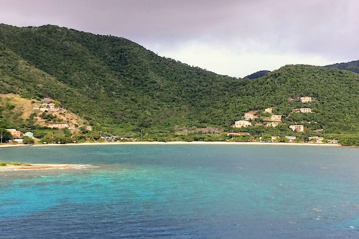 Beautiful beach cove in Tortola with houses on the hillside by the beach. 