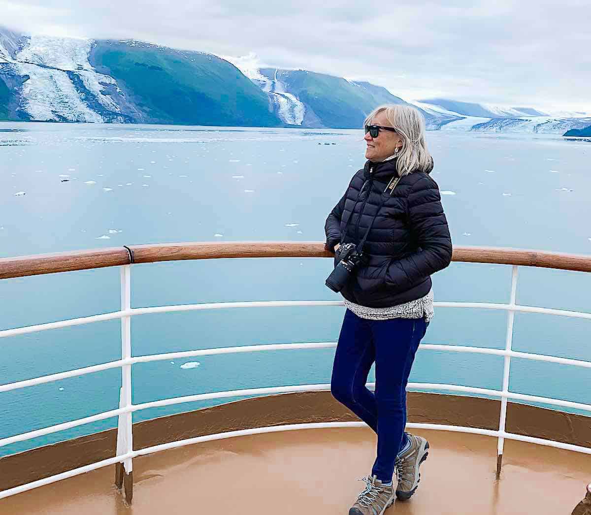 Sherry stands near the railing of a cruise ship on Alaska cruise.