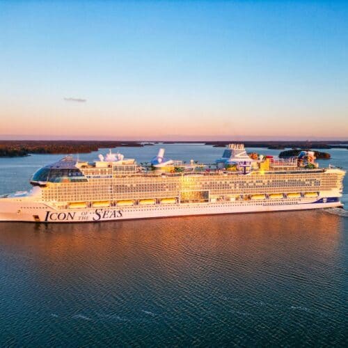 Royal Caribbean Icon of the Seas at sea during sunset.