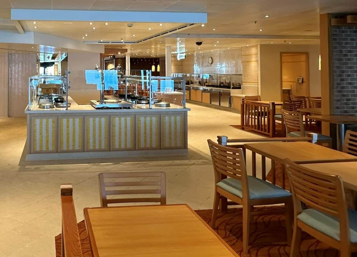 Carnival Vista Lido Marketplace with buffet counter and table and chairs.