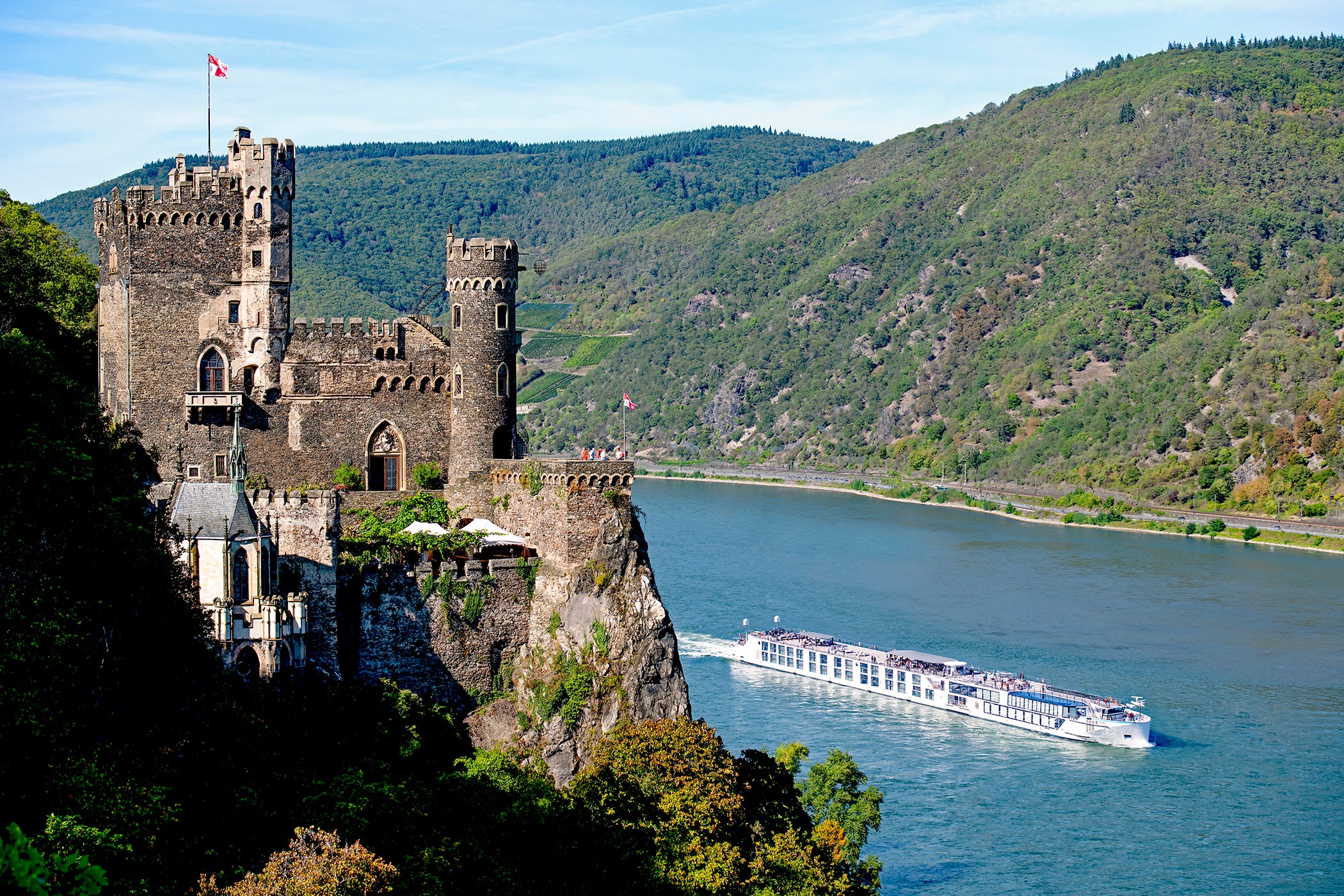 Riverside luxury cruise ship sailing past Rheinfels Castle in Germany